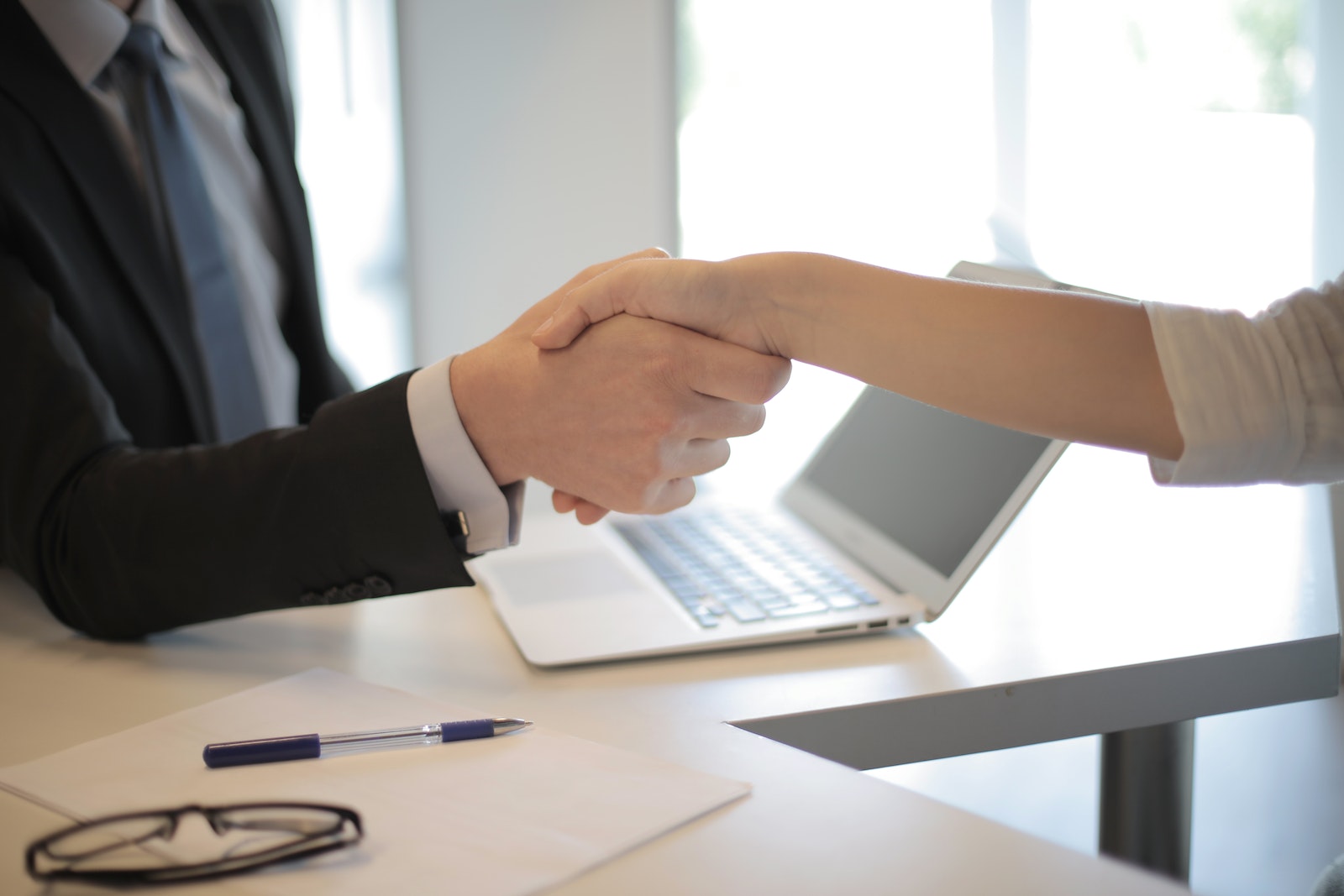 Person in Black Suit Hired shakes an hand